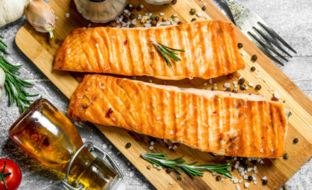 grilled farmed salmon on wood board