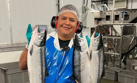 Person holding fresh salmon fish.